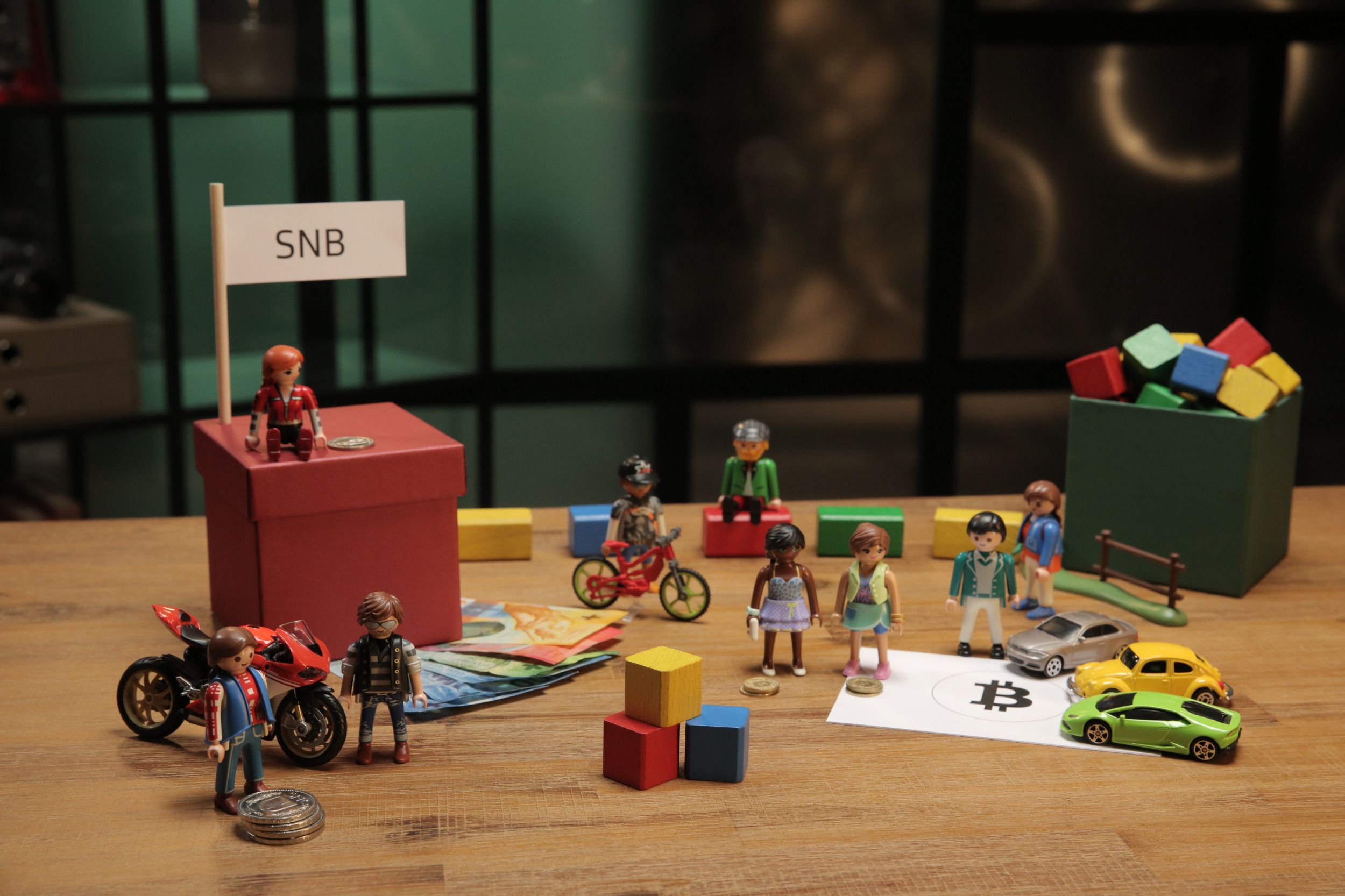 Verschiedene Playmobilfiguren und Spielsachen aus der Fernsehserie stehen auf einem Tisch. 